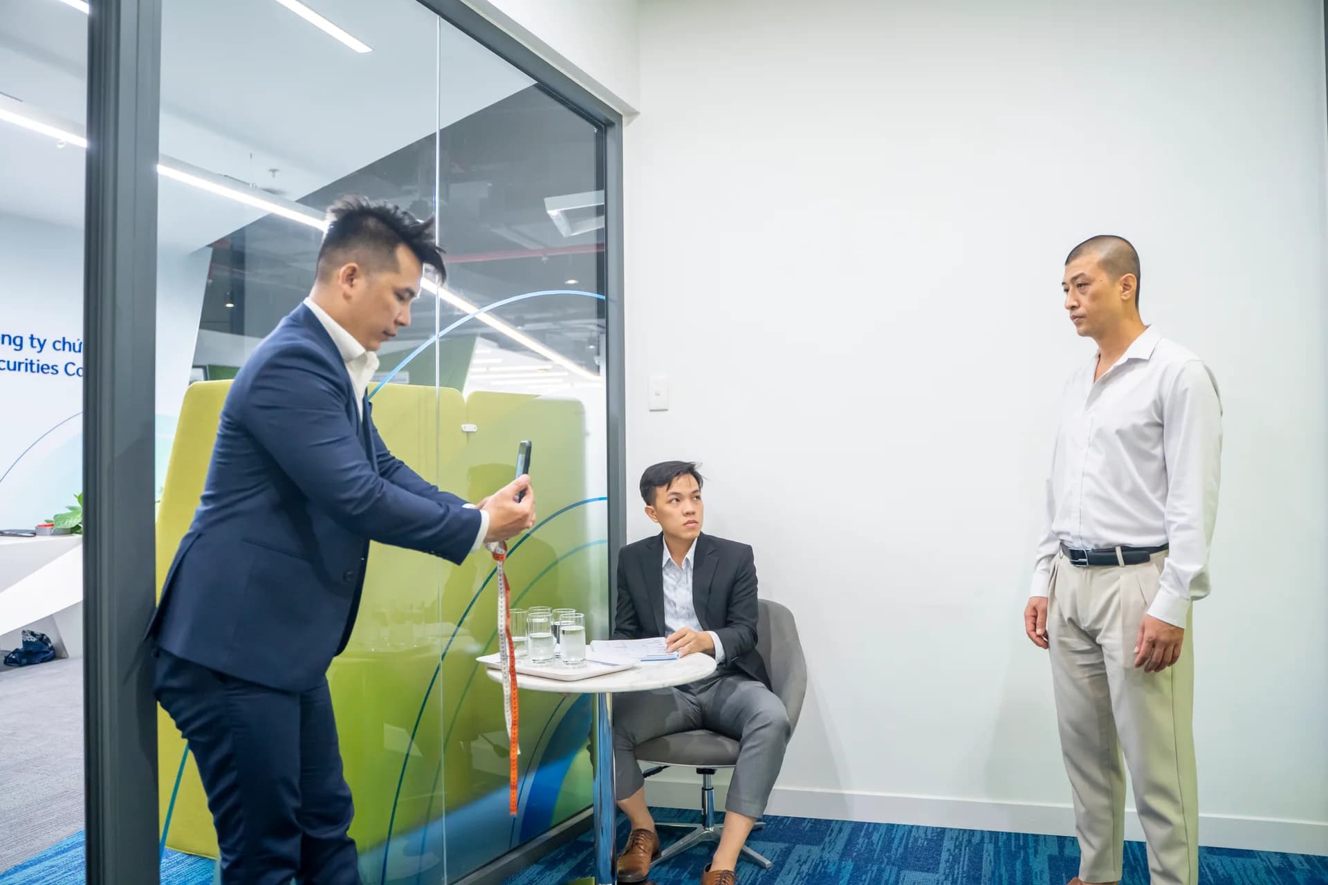 Chụp ảnh lưu dáng người trước khi đo, nhân viên đứng đúng tư thế trong buổi chuẩn bị may đồng phục veston