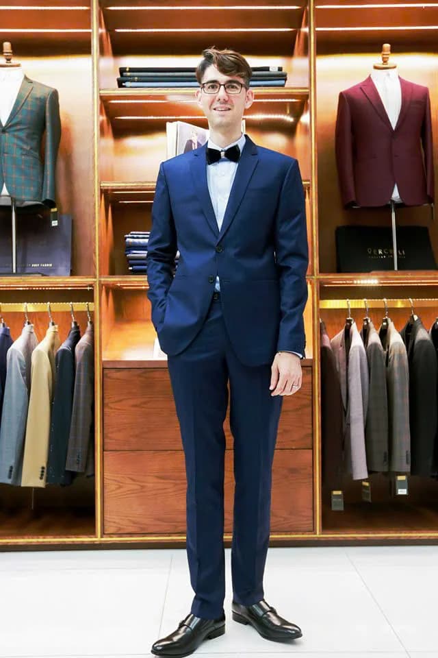 Chàng trai đeo kính mặc vest navy, nơ đen thanh lịch, gợi ý phối màu vest cho chú rể bên cô dâu áo dài