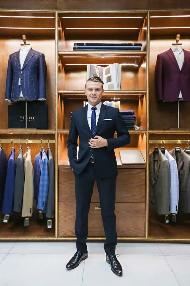 Khách Tây tóc vàng mặc suit navy, cà vạt chấm bi, minh họa áo vest may đo theo yêu cầu