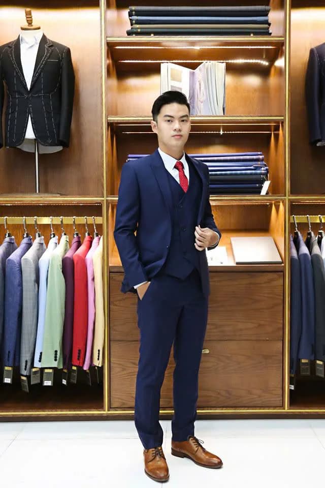 Quý ông mặc suit ba mảnh xanh navy, cà vạt đỏ, giày nâu, minh họa các kiểu suit ba mảnh nam