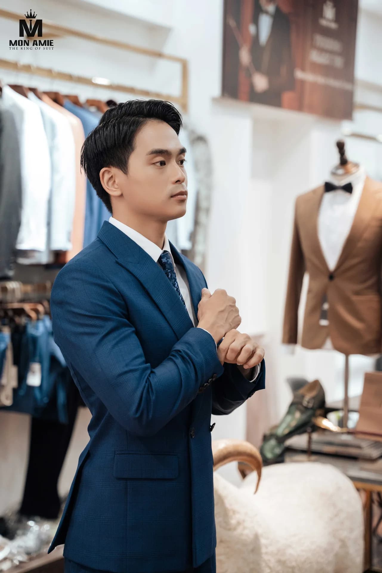 Chân dung trong showroom với vest xanh kẻ ô chìm và nút tay áo chỉn chu, vest nam may đo tại Nguyễn Trãi