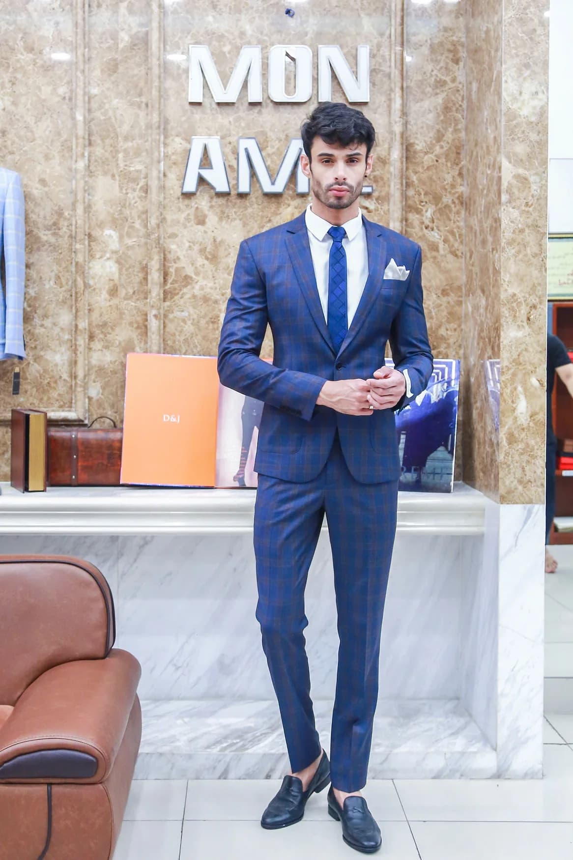 Người mẫu mặc vest caro xanh nâu, khăn túi trắng, gợi ý gam màu vest nam mùa hè
