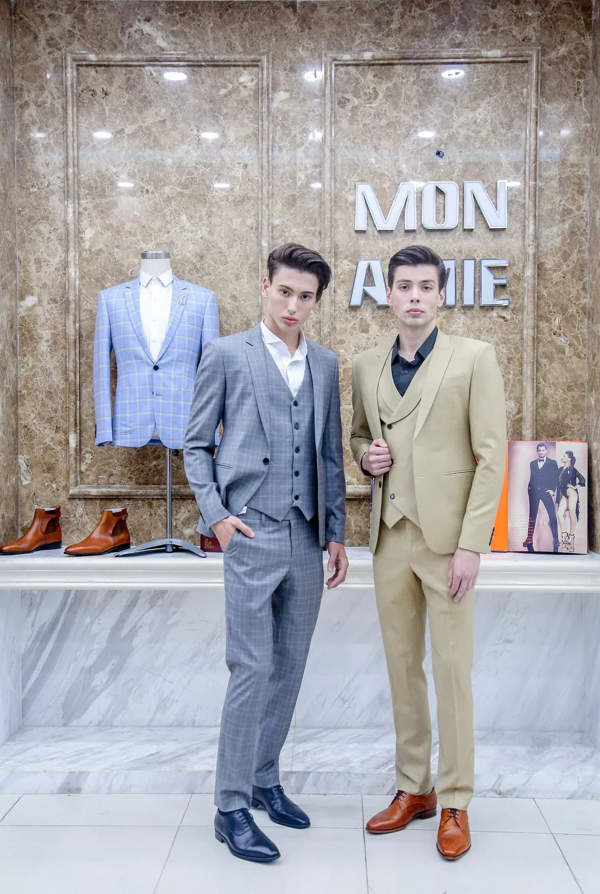 Hai người mẫu mặc vest xám caro và vest be, gợi ý gam màu cho bài mẫu vest bé trai theo độ tuổi