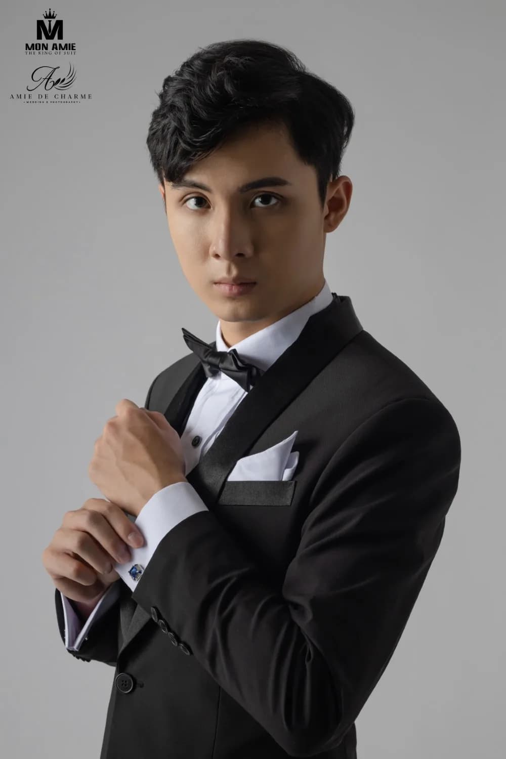 Cận cảnh tuxedo đen với ve satin, nơ đen, khăn cài túi và khuy măng sét, minh họa giá may đo tuxedo theo chi tiết